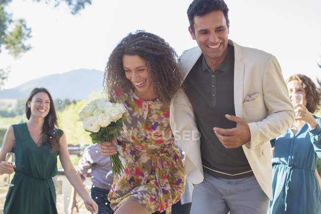 Couple running together at family picnic — Stock Photo