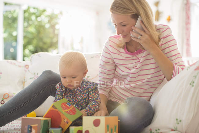 Mãe com bebê menina falando no telefone — Fotografia de Stock