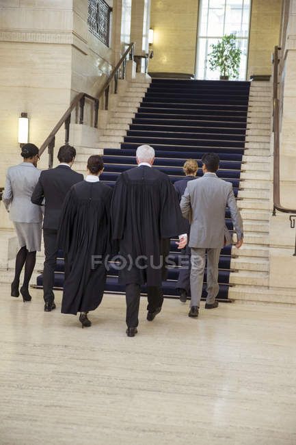 Jueces y abogados caminando juntos por el juzgado - foto de stock