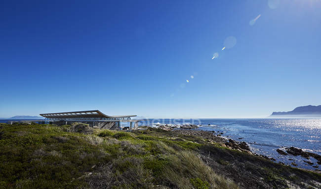 Maison de luxe avec vue sur l'océan sous un ciel bleu ensoleillé — Photo de stock