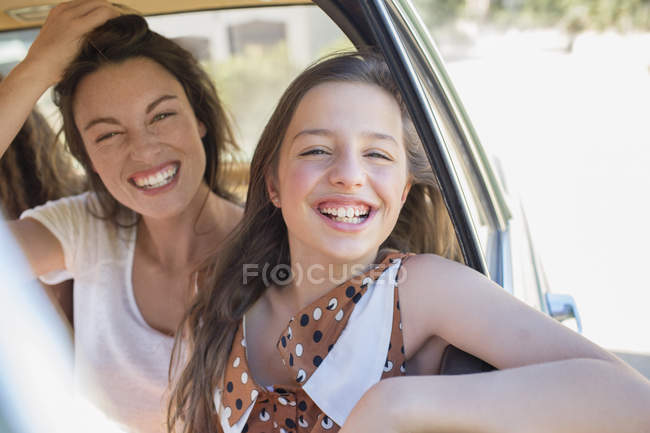 Irmãs modernas felizes rindo no banco de trás do carro — Fotografia de Stock
