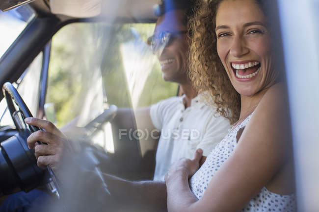 Feliz hermosa pareja cabalgando en coche juntos - foto de stock