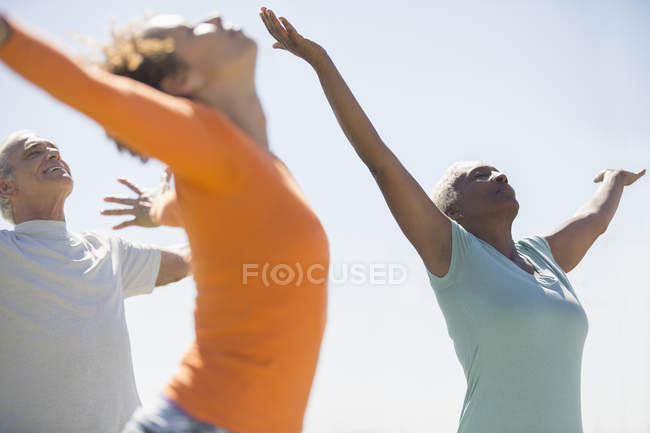 Seniors practicing yoga outdoors — Stock Photo