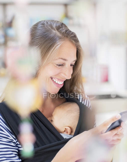 Madre con bebé niño usando teléfono inteligente - foto de stock