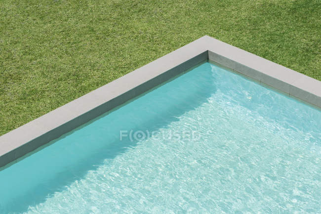 Vue ensoleillée sur la piscine dans la cour arrière — Photo de stock