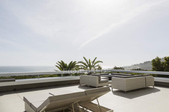 Soleggiato patio moderno di lusso con sedie a sdraio — Foto stock