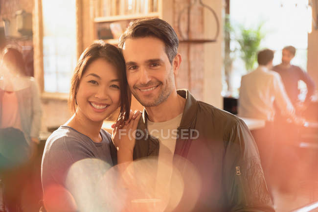 Retrato sonriente cariñosa pareja abrazándose en la cafetería - foto de stock