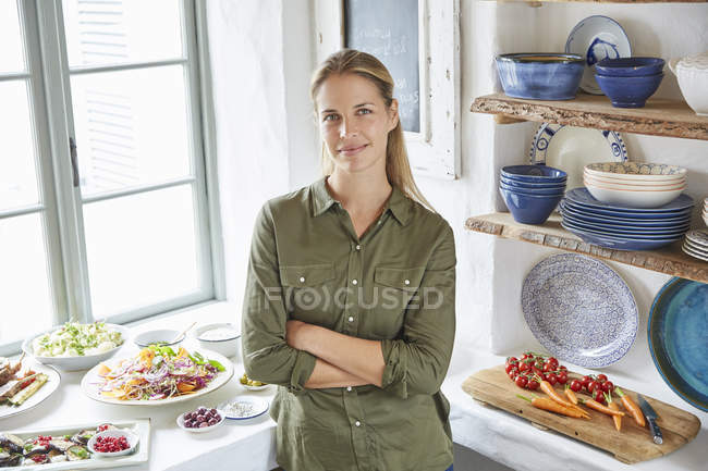 Retrato mujer sonriente en mesa buffet - foto de stock