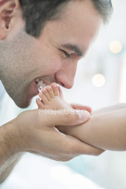 Père embrassant les pieds du bébé garçon — Photo de stock