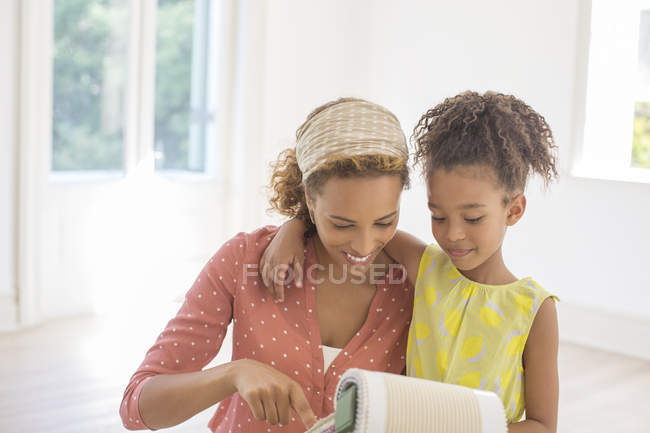 Mãe e filha olhando através de amostras de tecido juntos — Fotografia de Stock