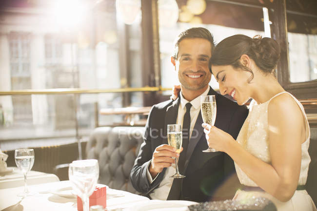 Well-dressed couple drinking champagne in restaurant — Stock Photo