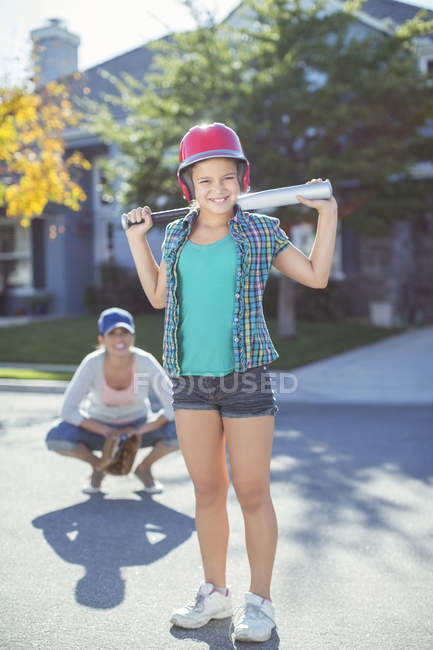 Retrato de madre e hija sonrientes jugando béisbol - foto de stock