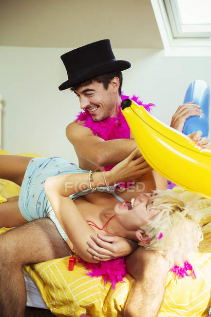Casal brincando juntos na cama depois da festa — Fotografia de Stock