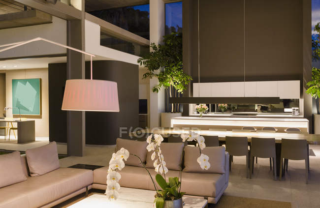 Iluminado moderno, casa de luxo vitrine interior sala de estar e cozinha — Fotografia de Stock