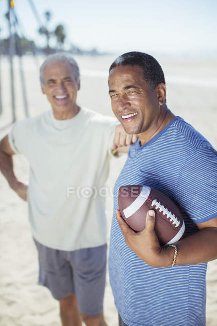 Homens seniores felizes com futebol na praia — Fotografia de Stock