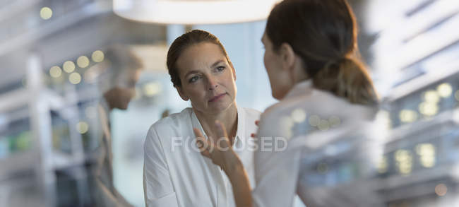 Attentive businesswoman listening to colleague in office — Stock Photo