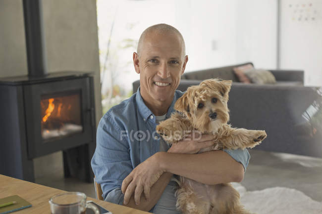 Ritratto sorridente uomo maturo che tiene simpatico cane — Foto stock