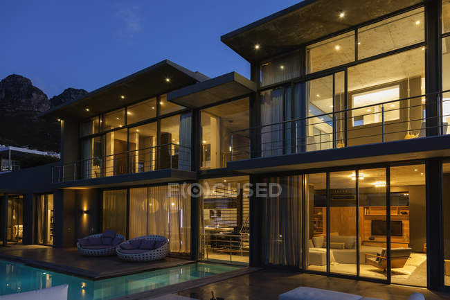 Maison de luxe avec piscine éclairée la nuit — Photo de stock
