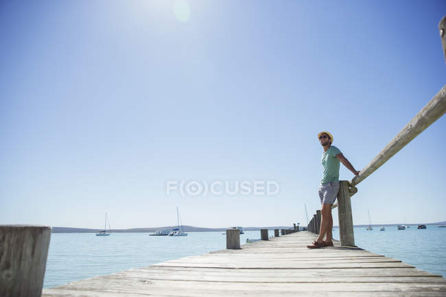 Чоловік стоїть на дерев'яному причалі — стокове фото