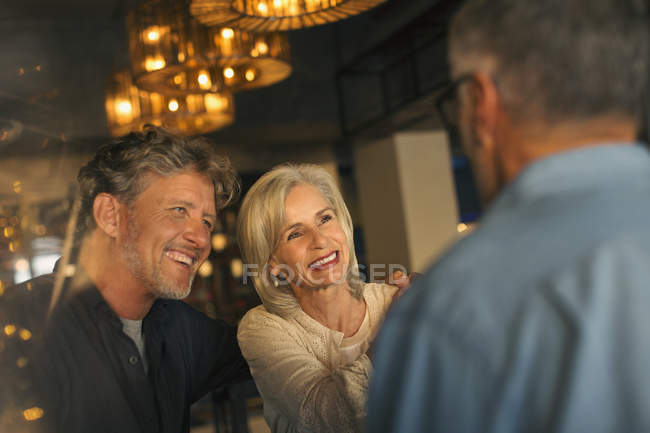 Des amis souriants parlent au restaurant — Photo de stock