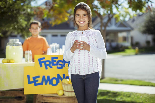Портрет усміхненої дівчини на підставці з лимонаду — стокове фото