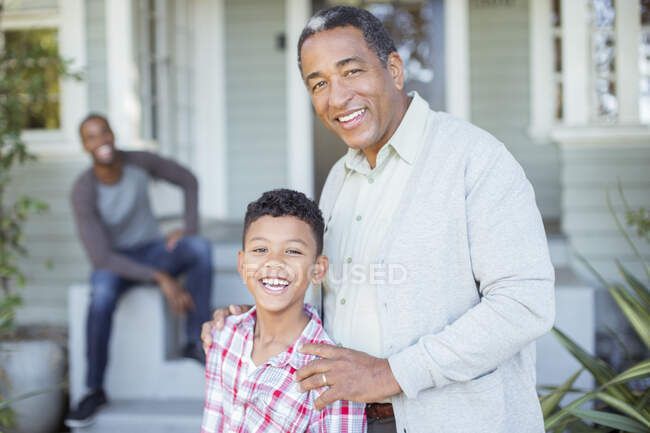 Портрет улыбающегося дедушки и внука у дома — стоковое фото