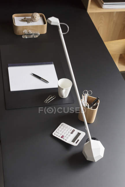 Objetos e lâmpada moderna em casa mesa de escritório — Fotografia de Stock