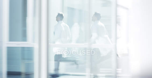 Doctors running in hospital corridor — Stock Photo