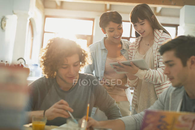 Jeunes couples étudiants de collège étudiant en utilisant une tablette numérique — Photo de stock