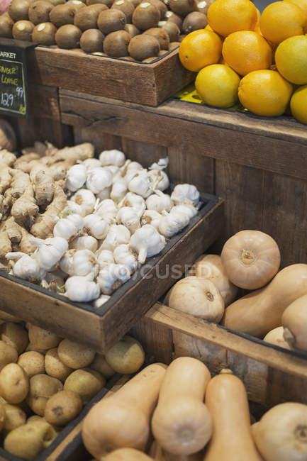 Présentoir d'ail, de gingembre, de pommes de terre et de courge musquée sur le marché de l'épicerie — Photo de stock