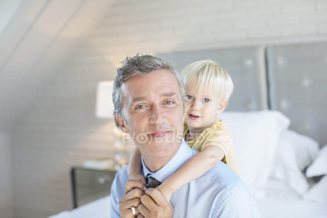 Отец носит сына на спине — стоковое фото