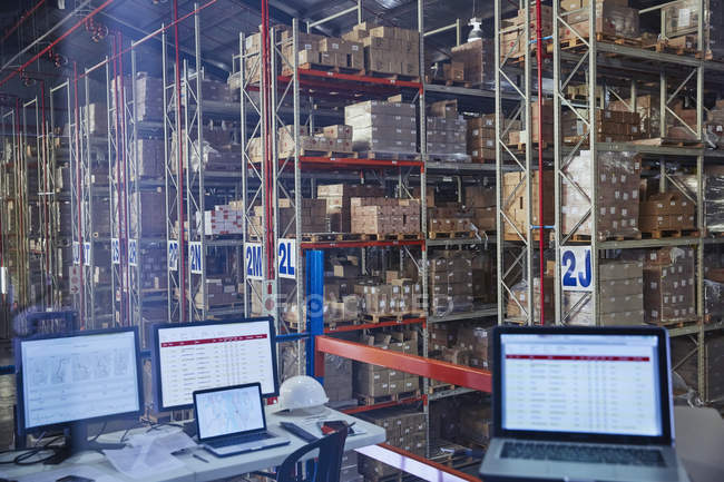Ordinateurs portables et ordinateurs dans l'entrepôt de distribution — Photo de stock