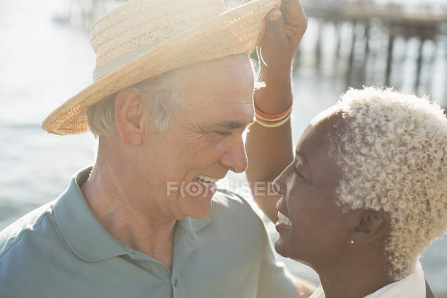 Щаслива багаторасова старша пара на сонячному пляжі — стокове фото