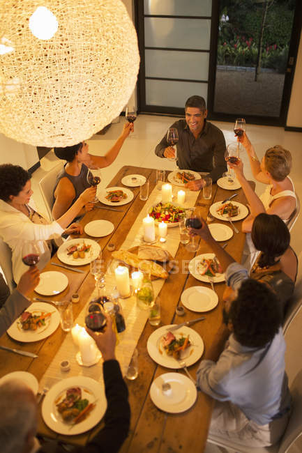 Freunde stoßen bei Dinnerparty aufeinander an — Stockfoto