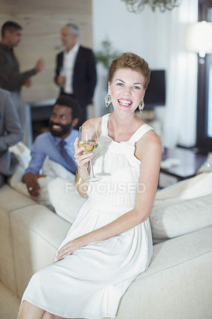 Жінка посміхається на дивані на вечірці — стокове фото