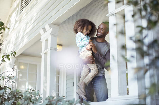 Щасливий батько носить дочку на ганку — стокове фото