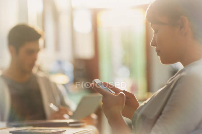 Молодая женщина пишет смс с мобильного телефона — стоковое фото