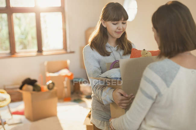 Young women moving packing boxes — Stock Photo