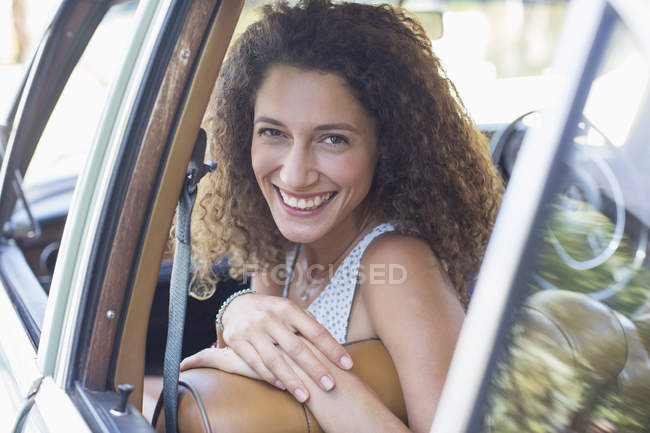 Mulher bonita feliz montando no carro no dia ensolarado — Fotografia de Stock