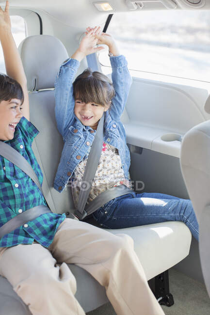 Entusiasta fratello e sorella nel sedile posteriore della macchina — Foto stock