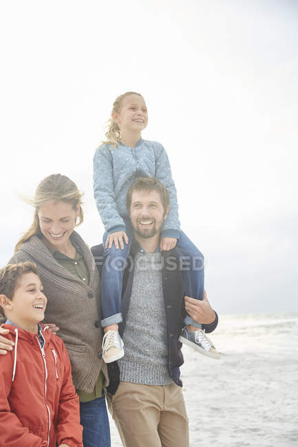 Усміхнена сім'я, що йде на зимовому пляжі — стокове фото