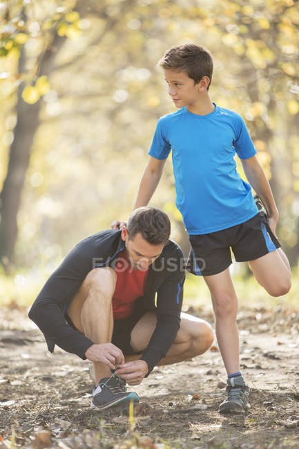 Батько і син тягнуться і готуються бігати — стокове фото