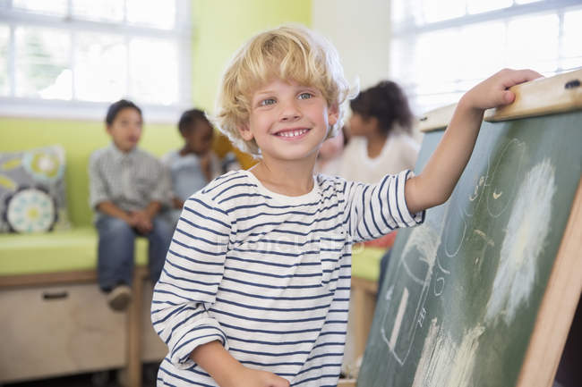 Student drawing on chalkboard in classroom — Stock Photo