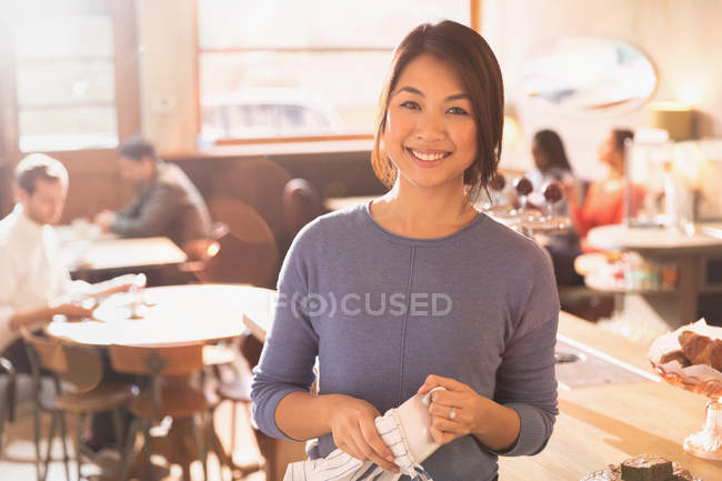 Retrato sonriente barista femenina en la cafetería - foto de stock