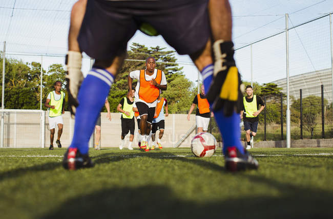 Vista a nivel de superficie de jugadores de fútbol entrenando en el campo - foto de stock