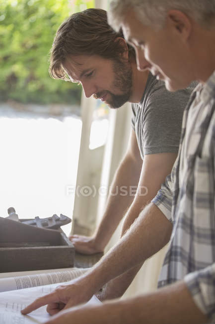 Padre e figlio che guardano insieme i documenti — Foto stock