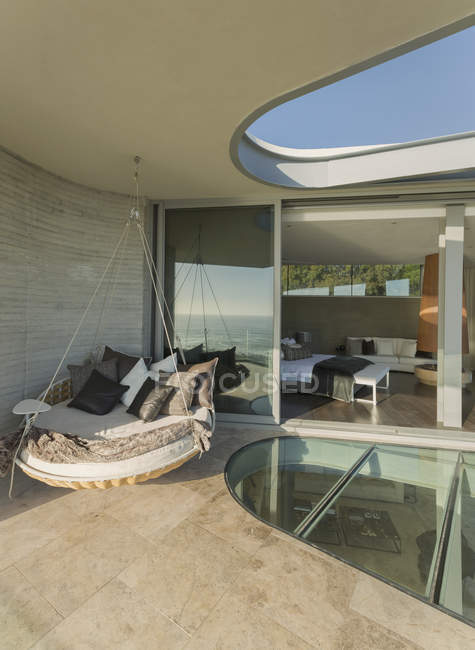 Cama de almofada pendurada no moderno pátio de vitrine em casa de luxo — Fotografia de Stock