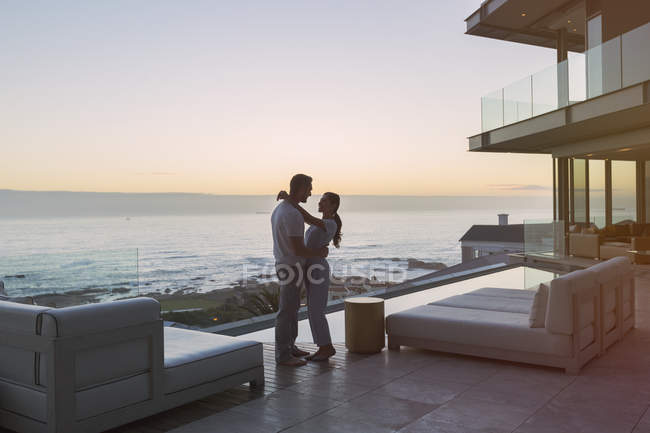 Casal afetuoso abraçando no pátio de luxo com vista para o mar — Fotografia de Stock