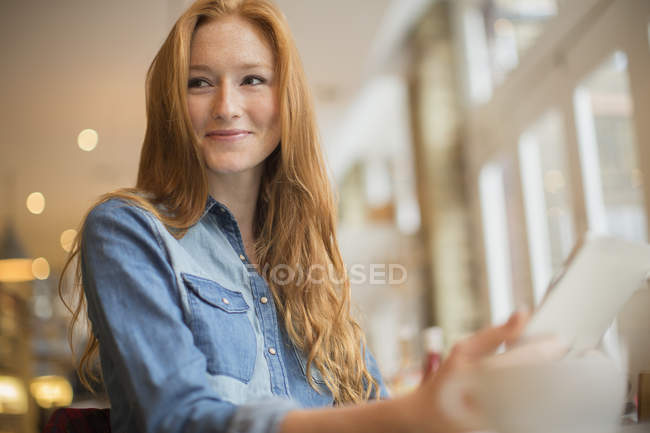 Heureuse jeune femme en utilisant tablette numérique dans le café — Photo de stock
