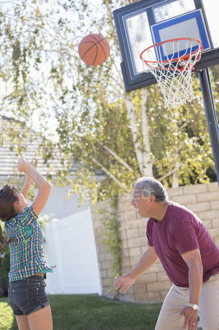 Дедушка и внучка играют в баскетбол — стоковое фото